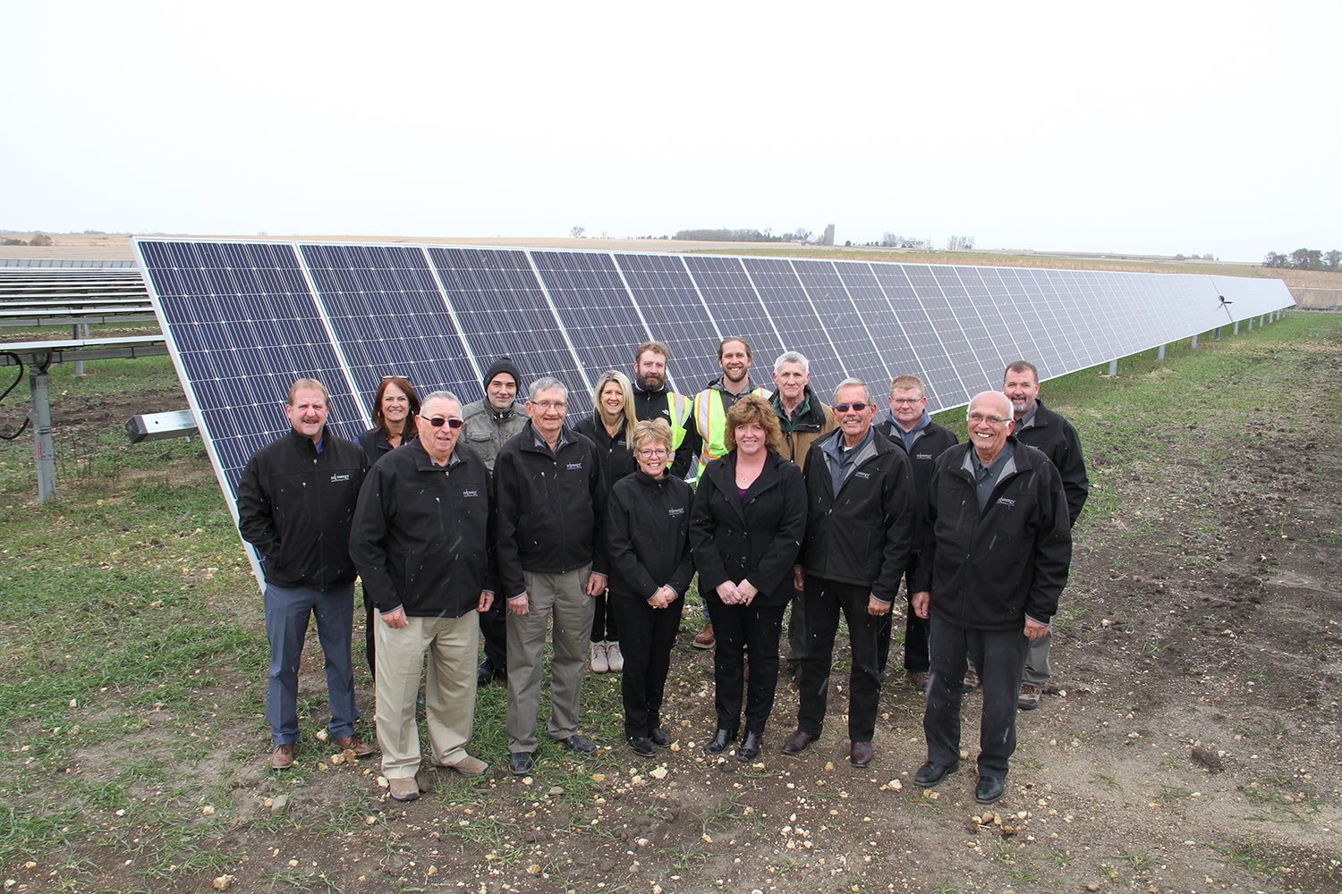 MiEnergy staff and board standing in front of solar panel
